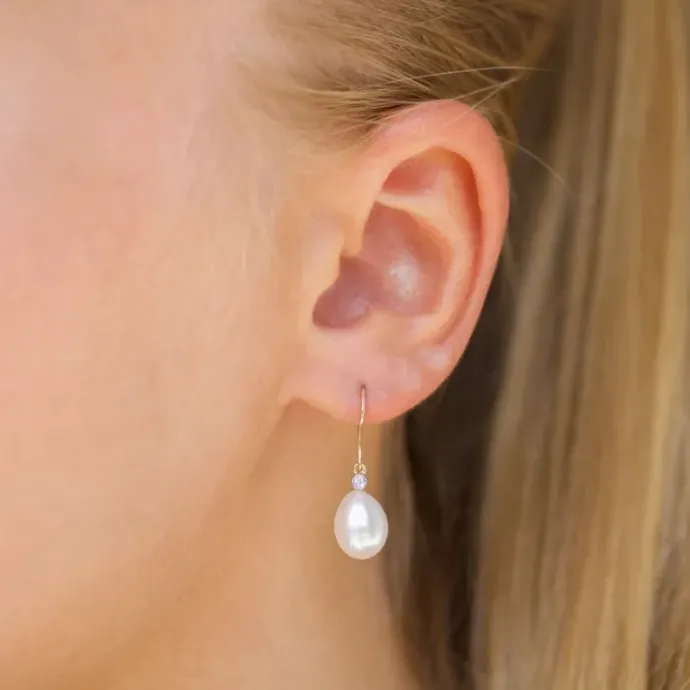 Ovale 7 - 8 mm aaa-graded ferskvandsperle diamantøreringe i 14 karat guld med diamanter